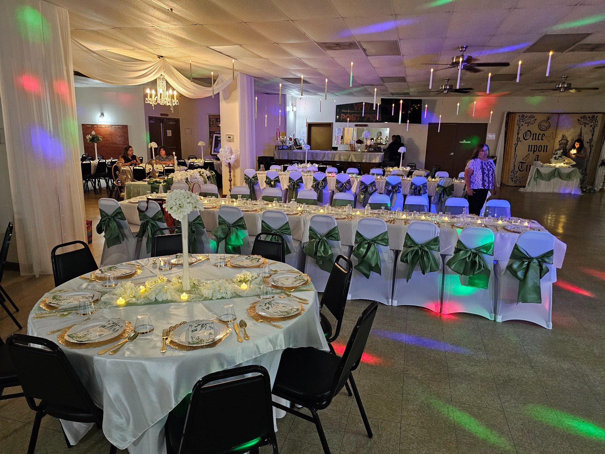 Green and white evening reception setup with tables and dance floor